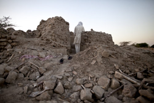A man prays at dawn where once was a mausoleum before it was destroyed by jihadist during the occupation at the Three Saints Cemetery in Timbuktu, North of Mali. Even though many mausoleums are now destroyed, many Malians continue to visit and worship the saints buried in Timbuktu, keeping alive an ancient religious practice.